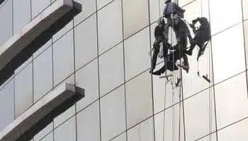 oto di un operatore per la pulizia di uffici con vetri alti